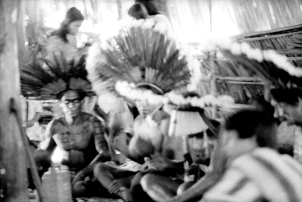 21/36 — SYLVIA CAIUBY NOVAES Homens reunidos na casa dos homens para o canto funerário, 1985 Aldeia do Tadarimana, MT Acervo da Autora